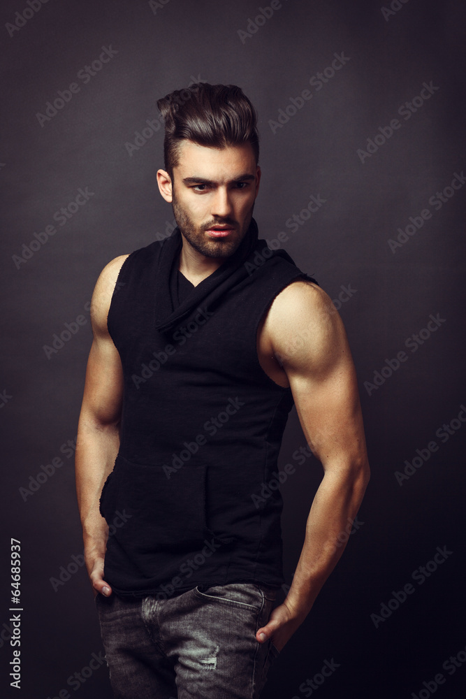 Handsome man posing in studio on dark background Handsome man posing in studio on dark background