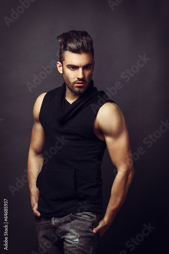 Handsome man posing in studio on dark background © djile