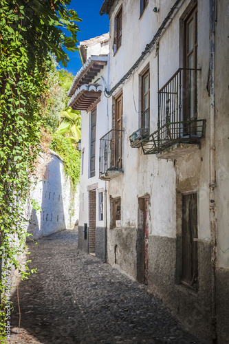 The narrow street with old houses, Granada, Spain. © anilah