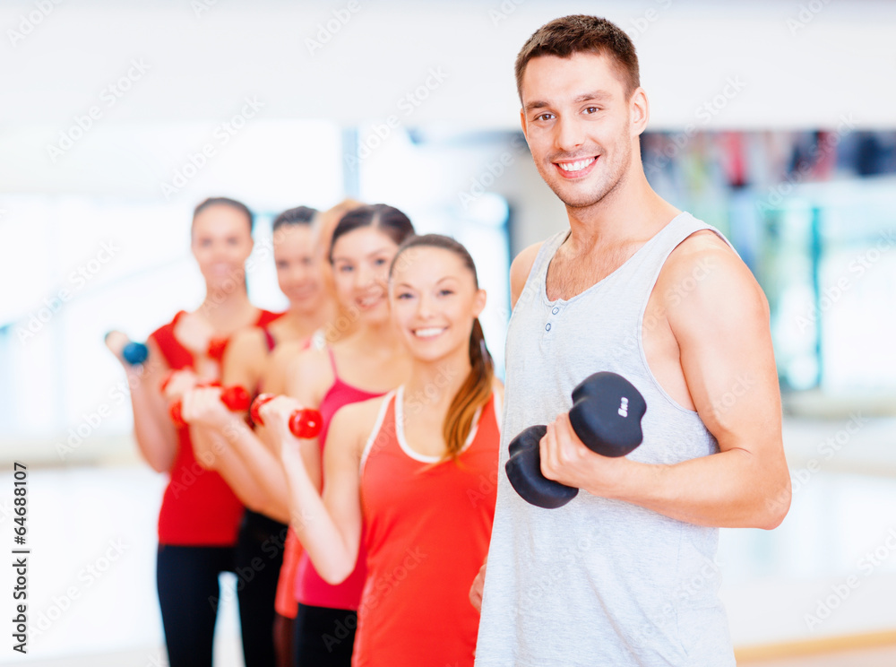 group of smiling people with dumbbells in the gym group of smiling people with dumbbells in the gym