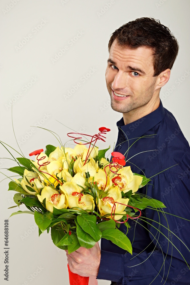 Man at shirt with bouquet of orchids, focus is on flowers Man at shirt with bouquet of orchids, focus is on flowers