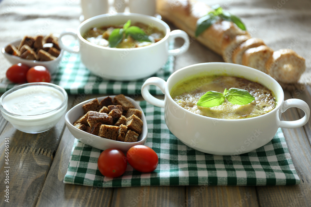 Tasty soup in saucepans on wooden table, close up