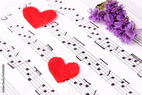 Red paper hearts on music book, close-up
