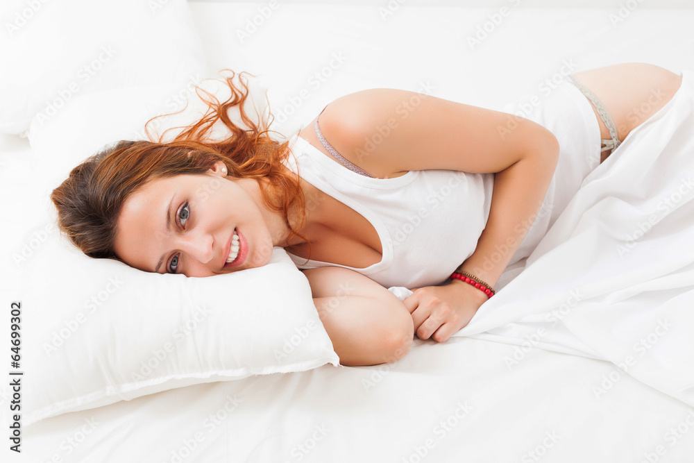 Fototapeta premium woman wakes up in her bed