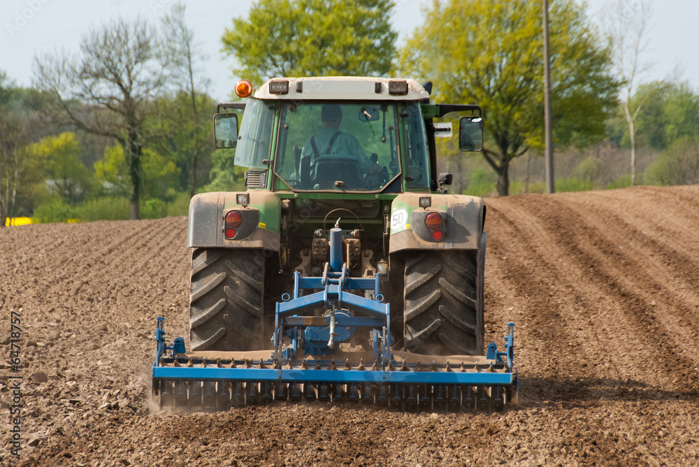 Naklejka premium Traktor mit Kreiselegge bei der Feldbearbeitung - 1524