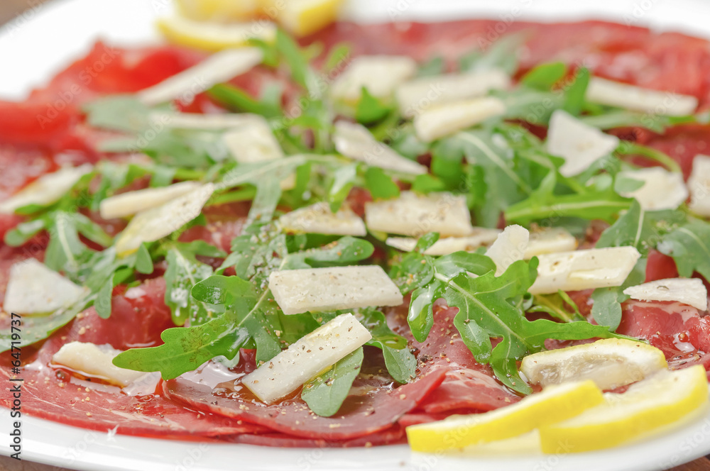 Closeup bresaola with arugula salad and olive oil Closeup bresaola with arugula salad and olive oil