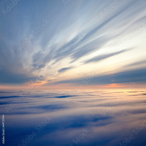 Flight between clouds during sunrise