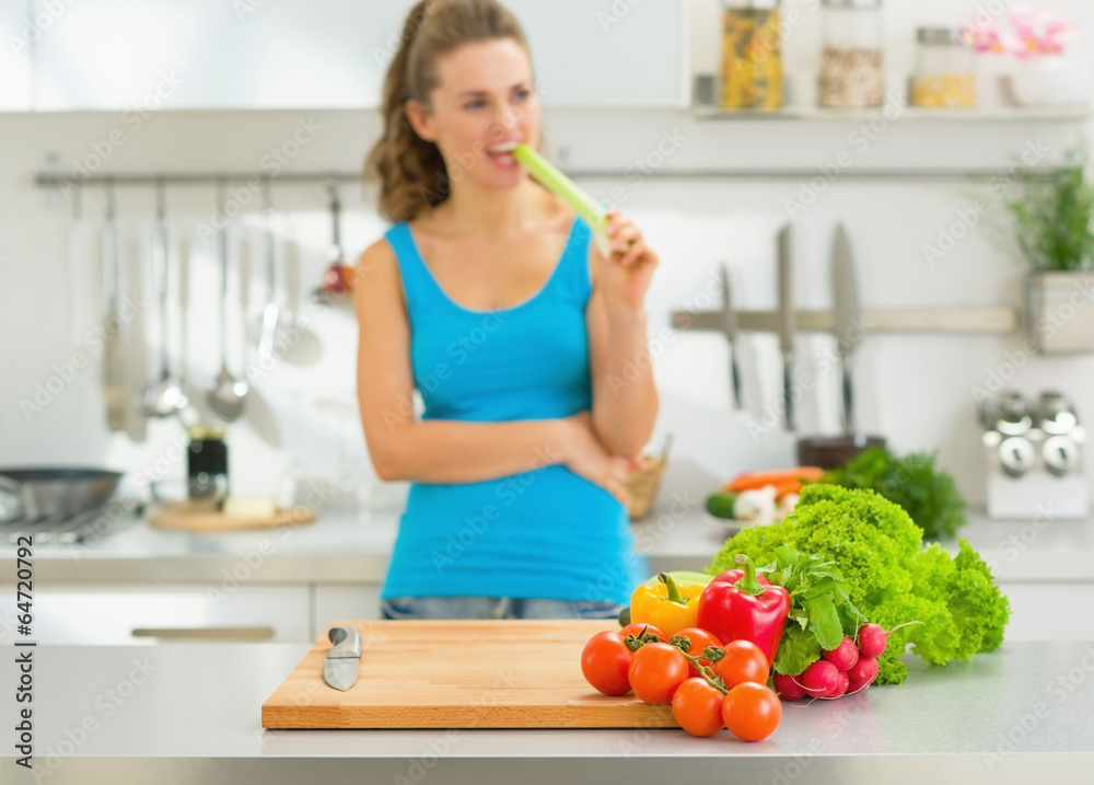 Closeup on fresh vegetables on table and woman in background