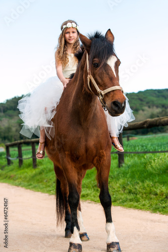 Girl riding brown horse.