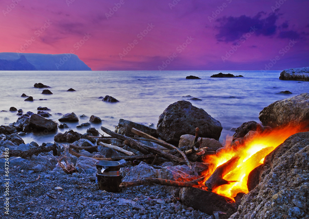 Wonderful landscape with bonfire on the seashore at sunset in Cr
