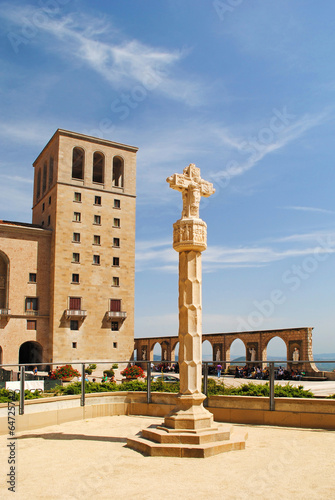 Stone cross in front of the Benedictine Abbey Santa Maria de Mon