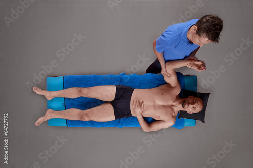 male therapist massaging muscular man's arm