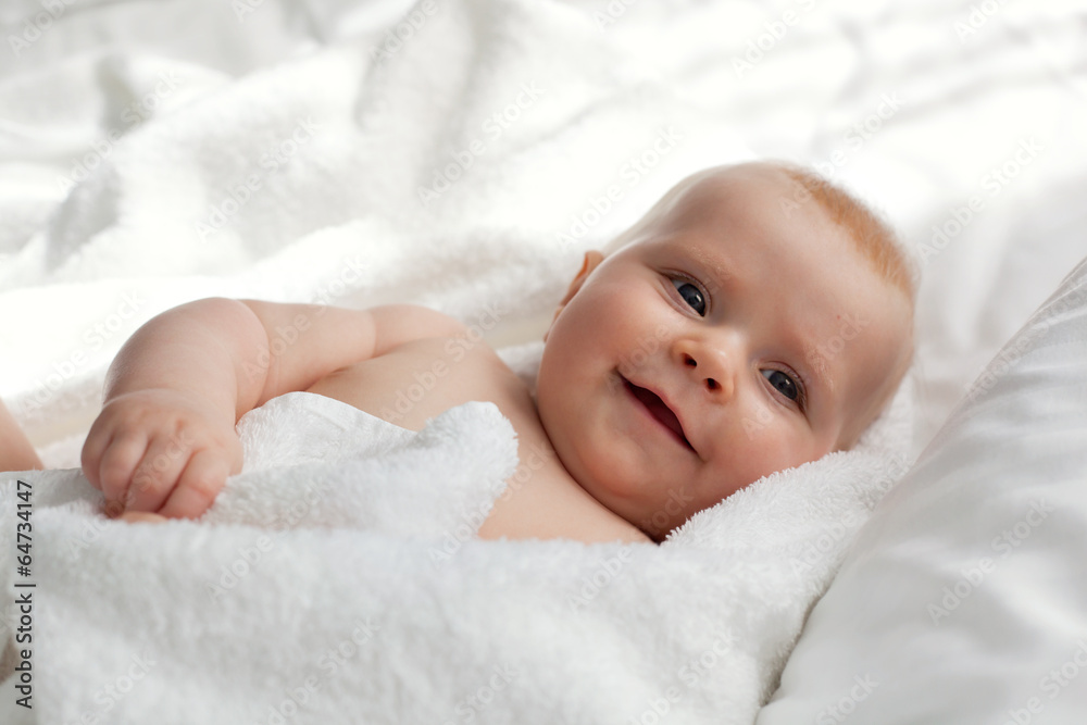 Newborn baby girl wrapped in a fluffy towel, smiling Newborn baby girl wrapped in a fluffy towel, smiling