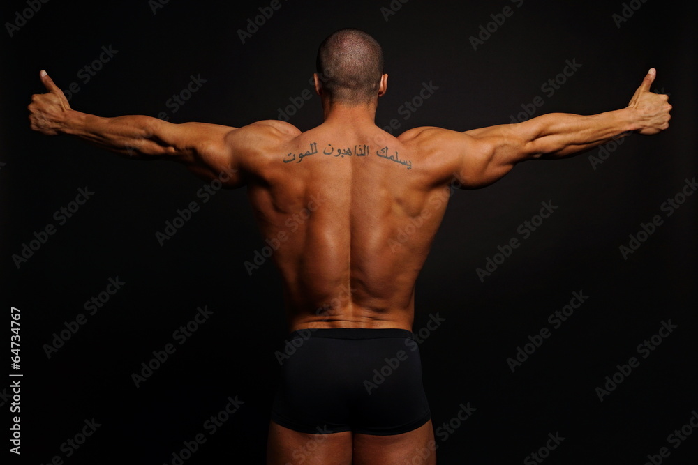 Muscular man with his arms outstretched showing his back