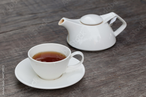 Cup of tea and tea's jar on old wooden