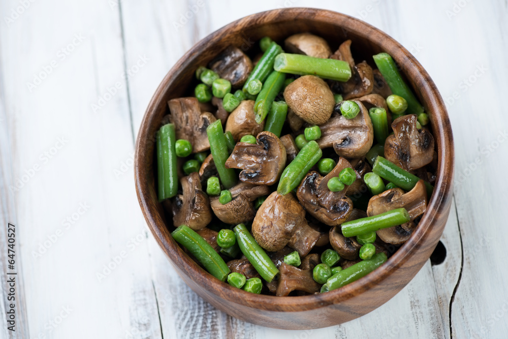 Roasted champignons with peas and beans in a bowl, above view Roasted champignons with peas and beans in a bowl, above view