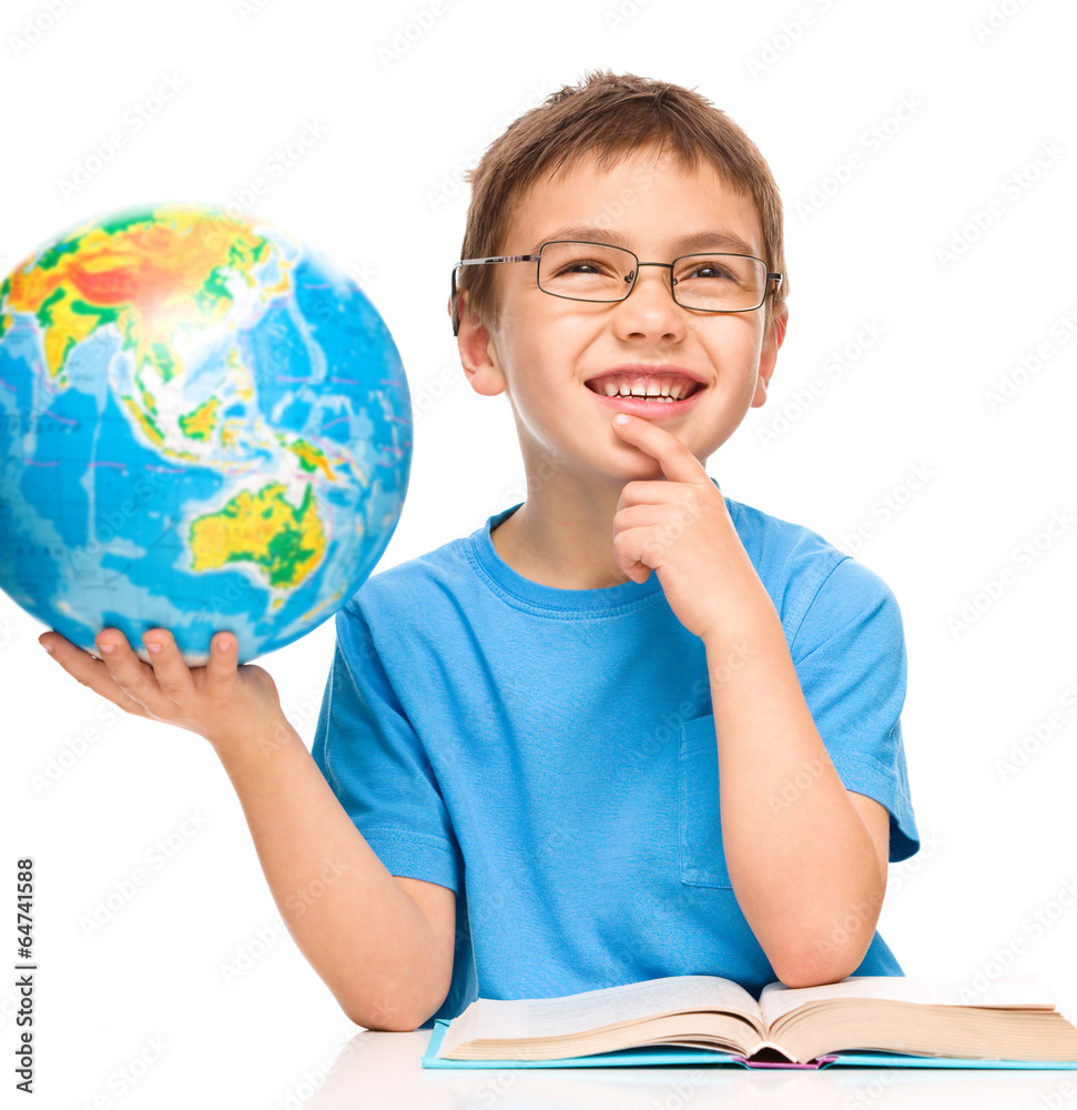 Little boy is holding globe while daydreaming Little boy is holding globe while daydreaming