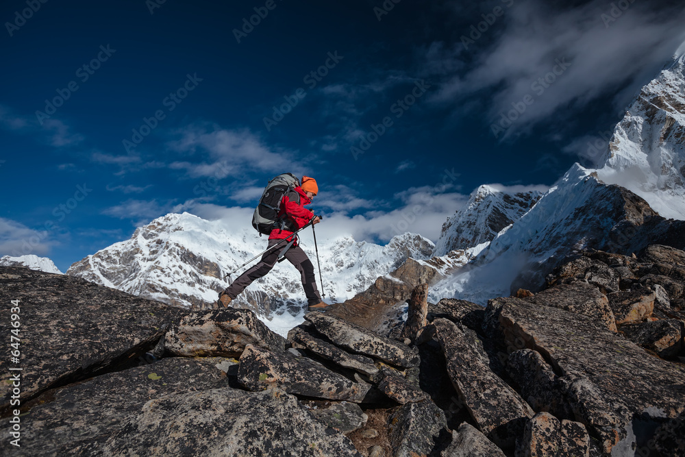 Hiker jumps over rocks in Himalaya mountains