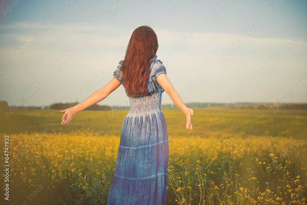 young free woman at spring meadow flowers