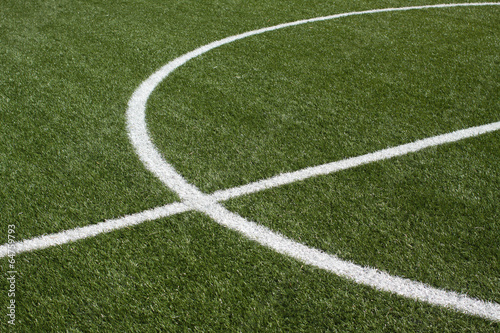 Part of a soccer field with synthetic grass and white lines