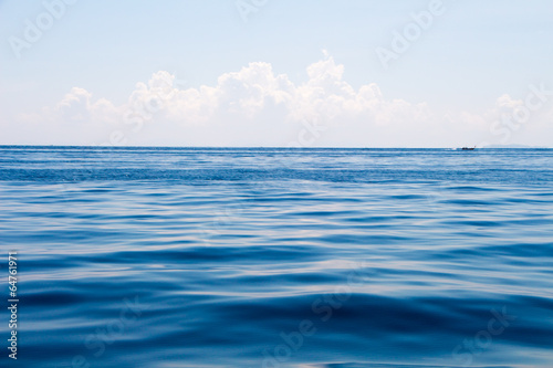 ocean surface and blue sky with clouds