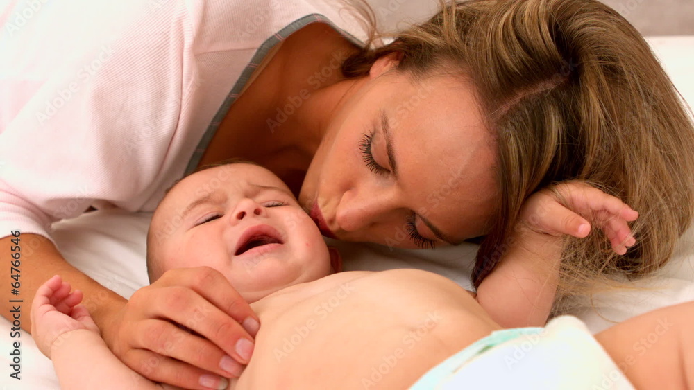 Cute baby on a bed with mother Cute baby on a bed with mother