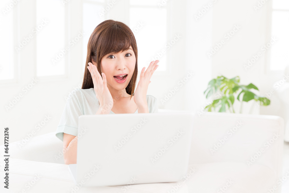 部屋でパソコンを使う女性