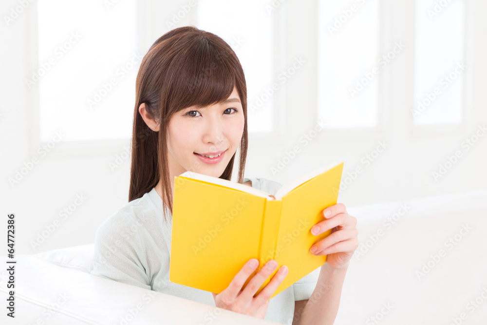 部屋で本を読む女性