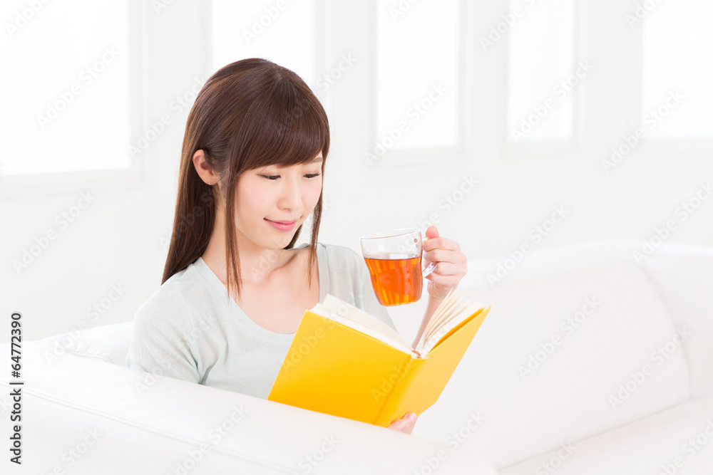 部屋で本を読む女性