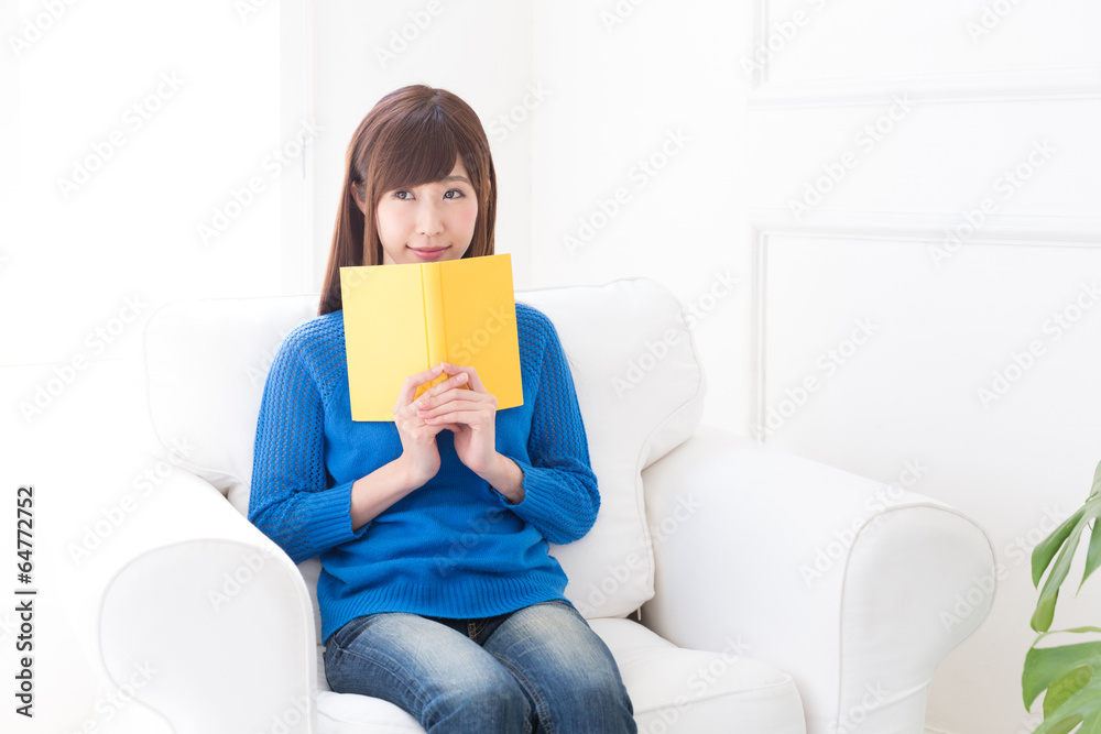 部屋で本を読む女性