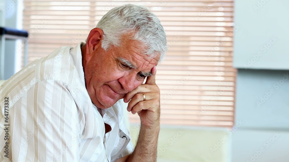 Depressed senior man sitting on the couch