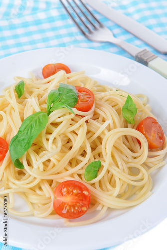 Delicious spaghetti with tomatoes on plate on table close-up