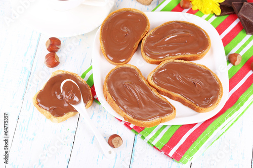 Bread with sweet chocolate hazelnut spread on plate on table