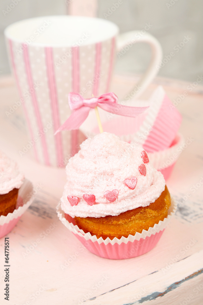 Tasty cup cake with cream on wooden chair Tasty cup cake with cream on wooden chair