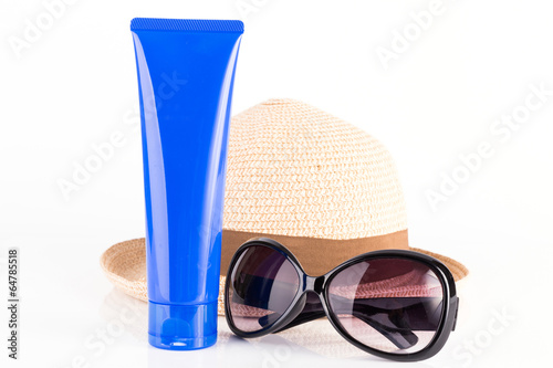 Sun protection accessories including blue tube of sunscreen, sunglasses and sun hat isolated on white