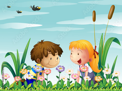 A cute girl and a cute boy watching the flowers