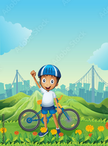 A boy and his bike standing across the tall mountains