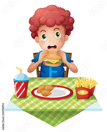 A curly-haired boy eating at a fastfood restaurant