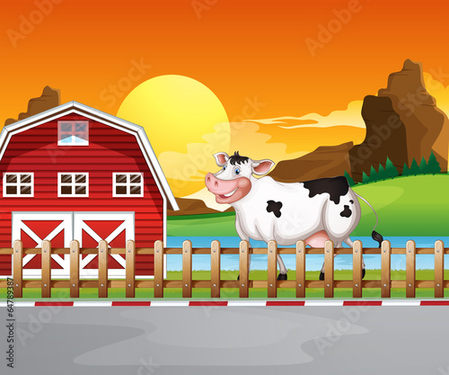 A cow beside the wooden barnhouse