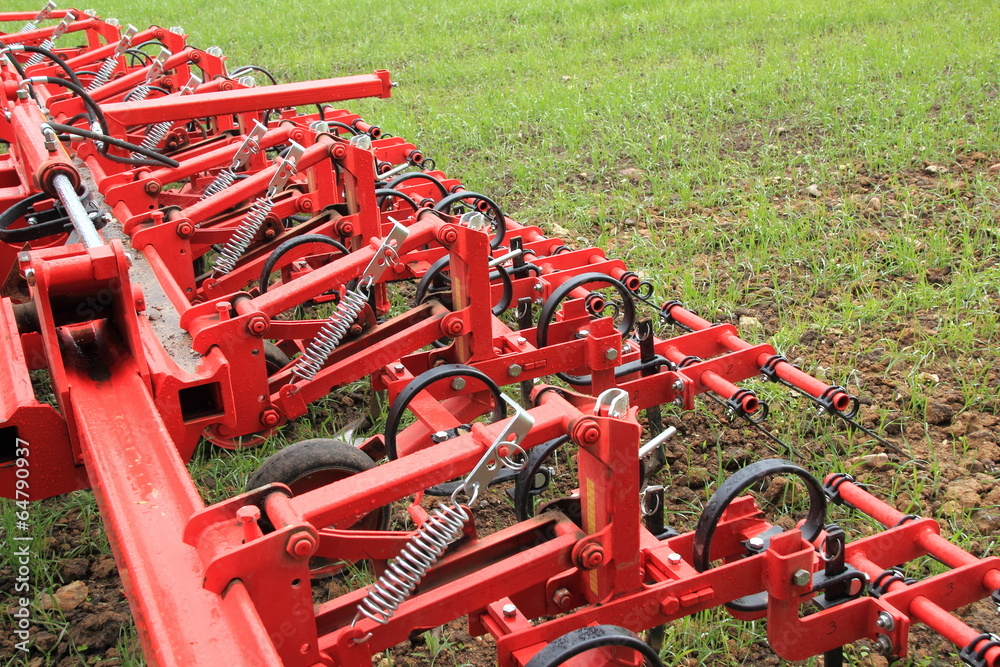 Harrow in green crop field after rainfall