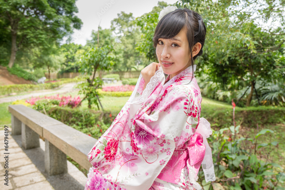 Asian woman wearing a yukata in Japanese style garden Asian woman wearing a yukata in Japanese style garden