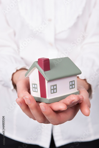 Beautiful young woman holding house model