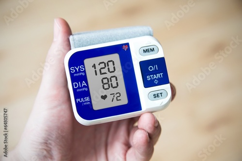 Hand holding blood pressure gauge photo