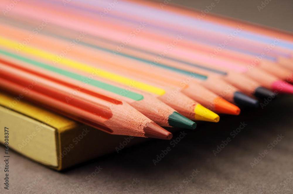 Naklejka premium Coloring pencils in a row on a notebook