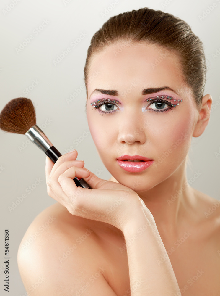 Beautiful young adult woman holds the make-up brushes Beautiful young adult woman holds the make-up brushes