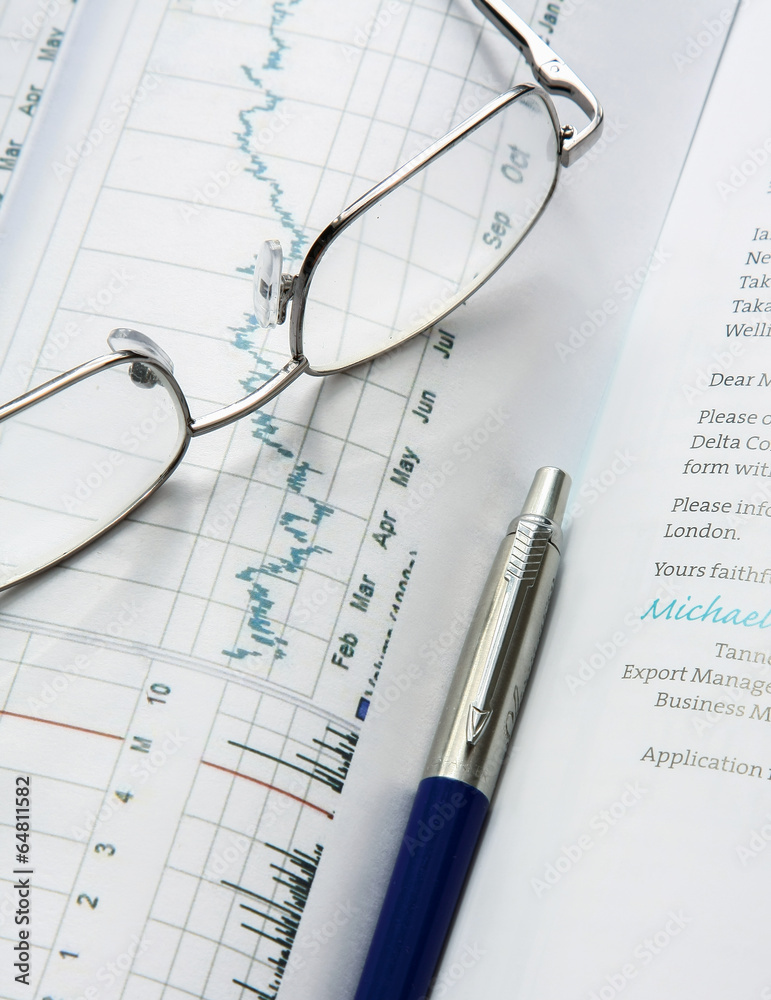 Eyeglasses lying down on a business document Eyeglasses lying down on a business document