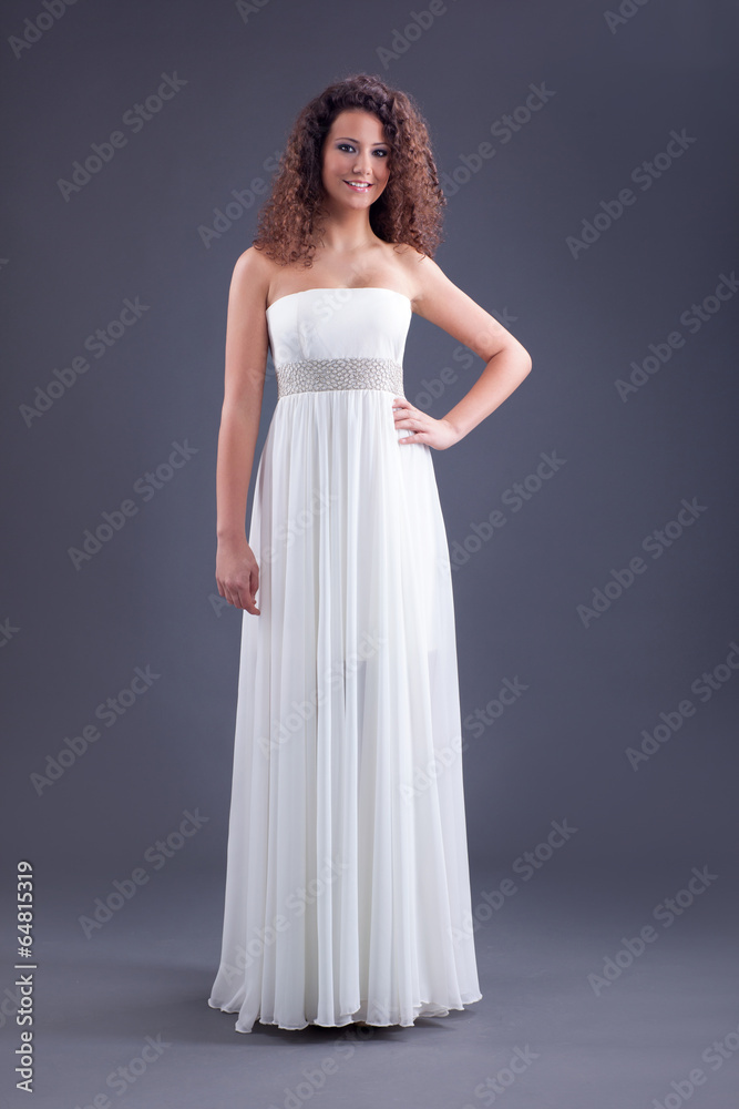 Young beautiful curly female model in white dress