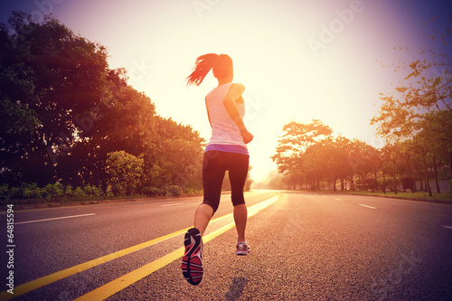 Runner athlete running on sunrise road photo