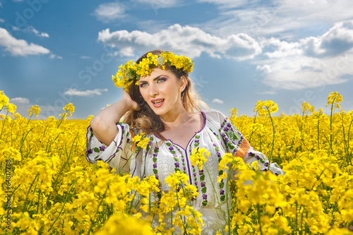 Obraz na płótnie Young girl wearing Romanian traditional blouse posing in canola w salonie