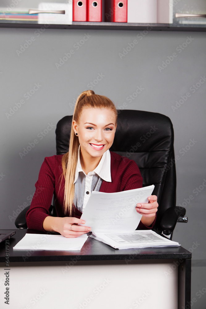 Smiling businesswoman with paper in office Smiling businesswoman with paper in office